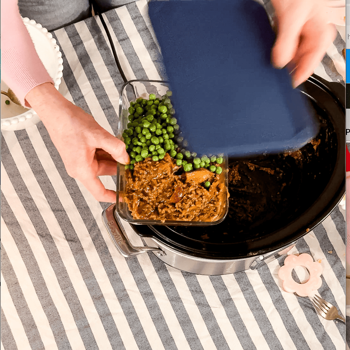 Person pouring green peas into ground beef mixture in slow cooker for homemade cooking
